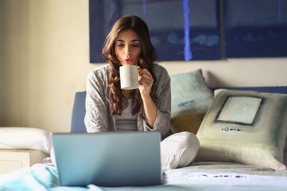 スタバのモーニングでパソコンをしながらコーヒーを飲む女性