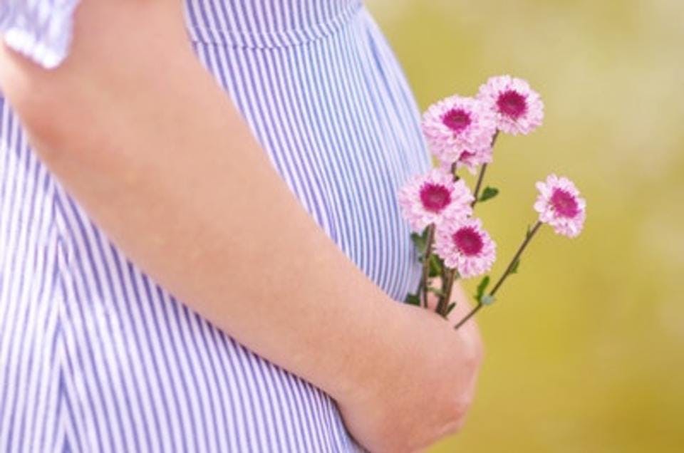 いつからママになれるか楽しみで花をもつ妊婦