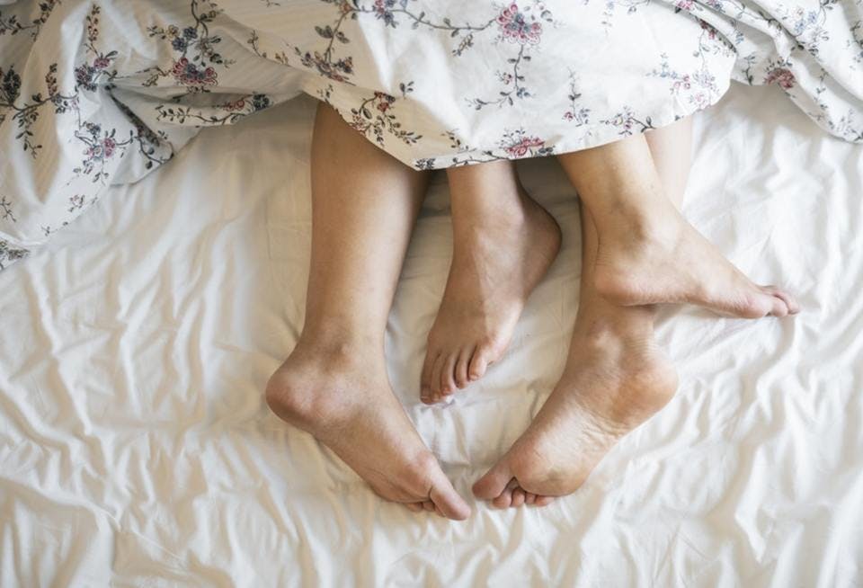 ベッドの上のカップルの脚