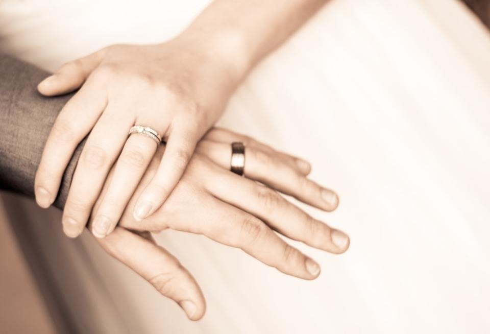 指輪をしているカップルの手
