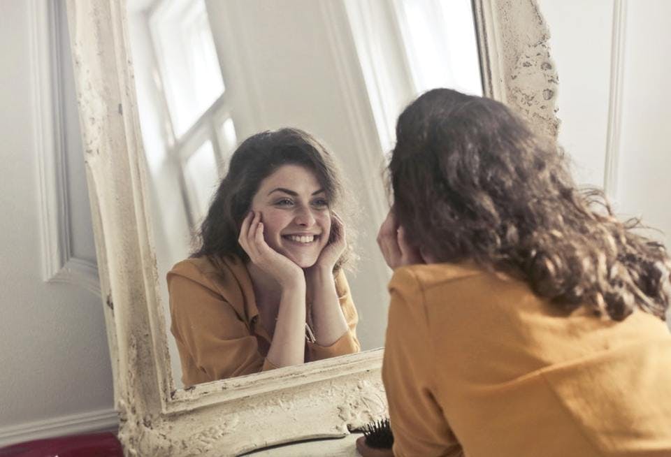 鏡の前で笑顔の女性