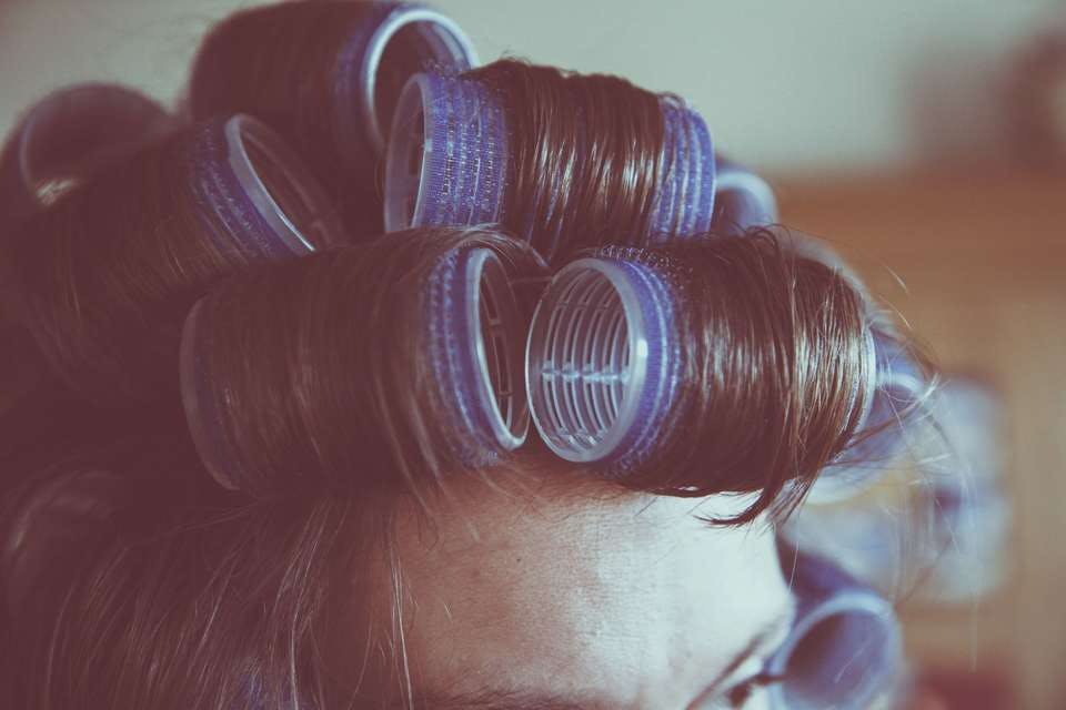 カーラーを使って留袖に似合う髪型をセルフで作る女性
