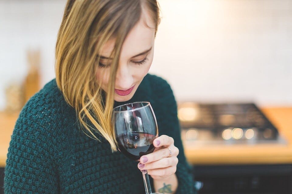 セーターをリメイクしてワインを飲む女性