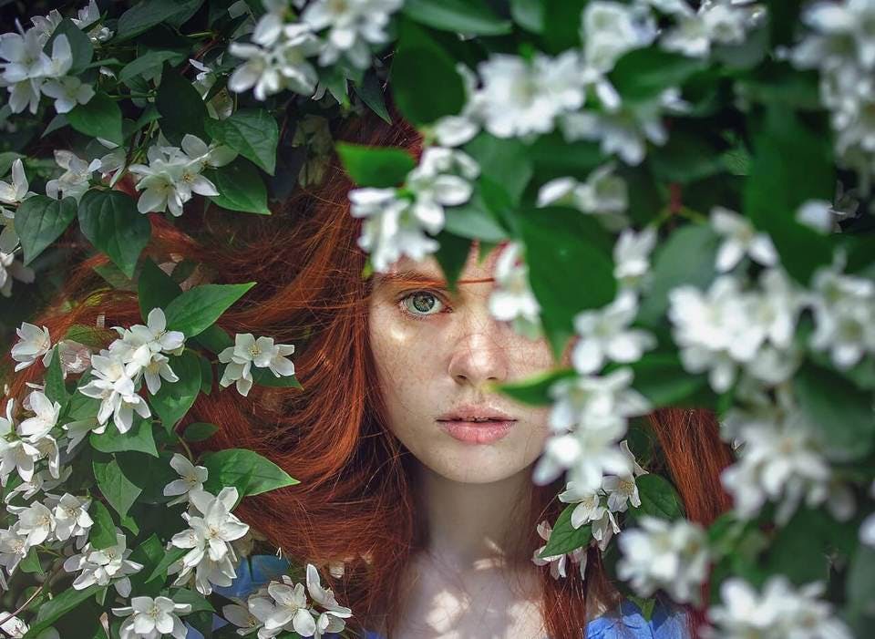 三白眼を隠そうと葉っぱに隠れている女性