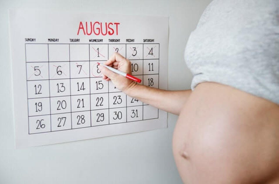 カレンダーにチェックをする妊婦の様子