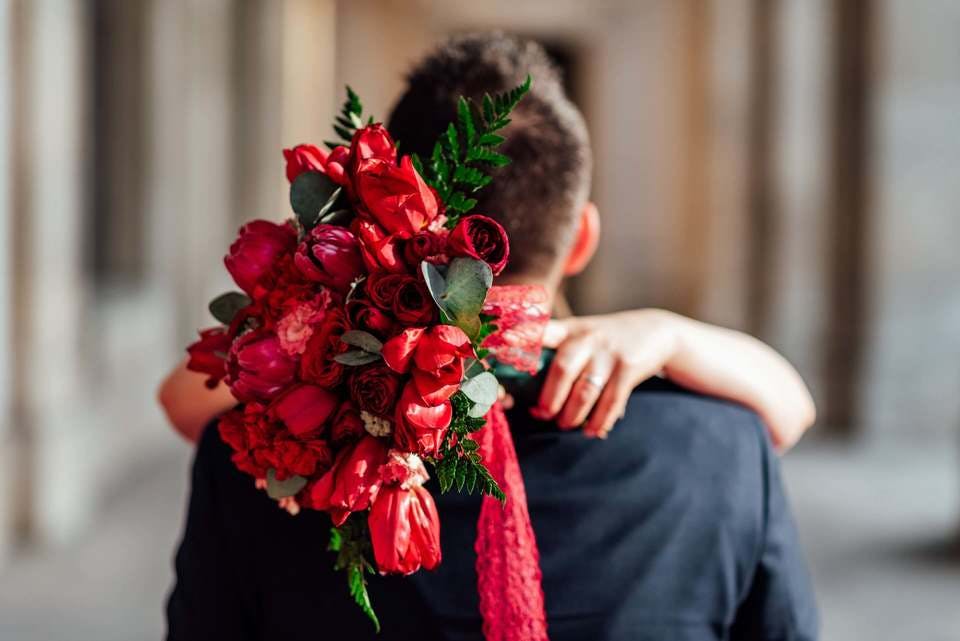決め手となった花束を手に結婚相手にキスする女性