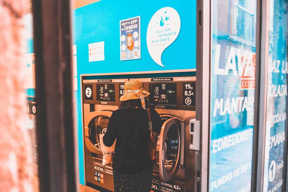ポリエステル衣類を洗濯機で洗っている女性