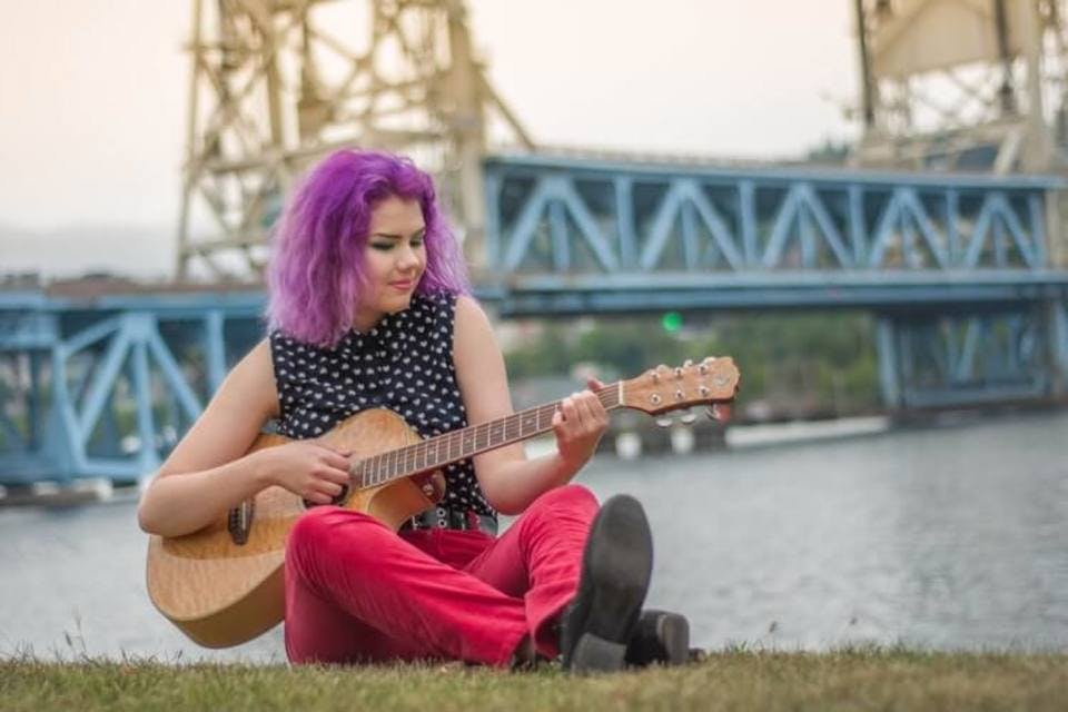 紫のカラートリートメントをしてギターを弾く女性