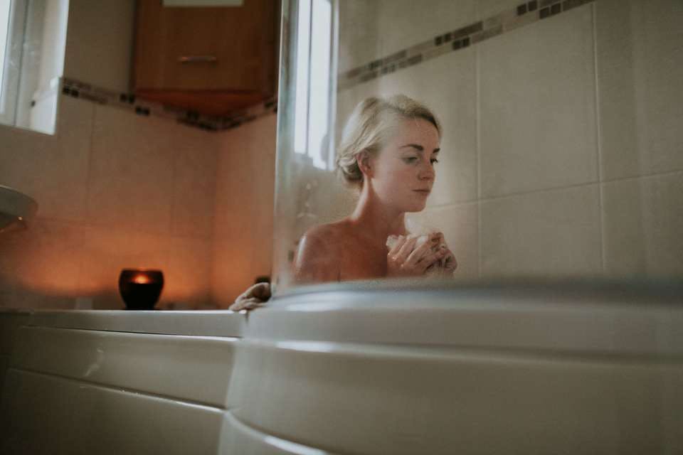 お風呂で目をぱっちりさせるマッサージをしようとしている女性