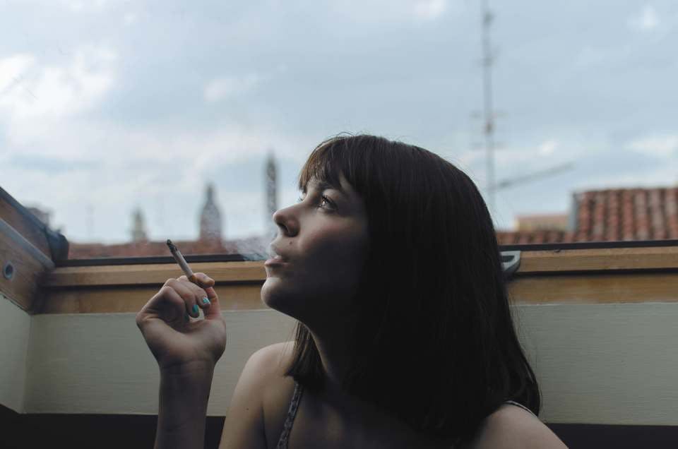 キスの前に臭いにおいのタバコを吸う女性