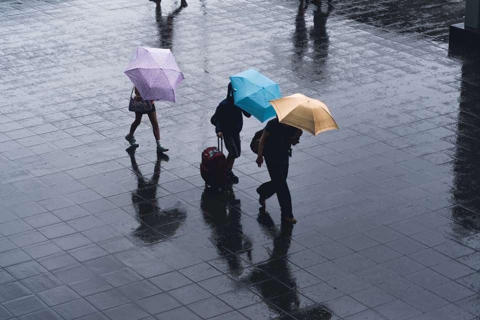 レディース向け折りたたみ傘を差して歩く人たち