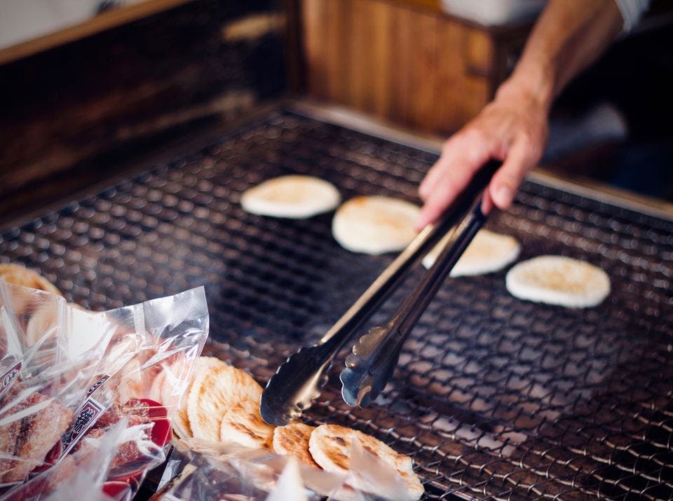 固い食べ物のせんべいを焼く人