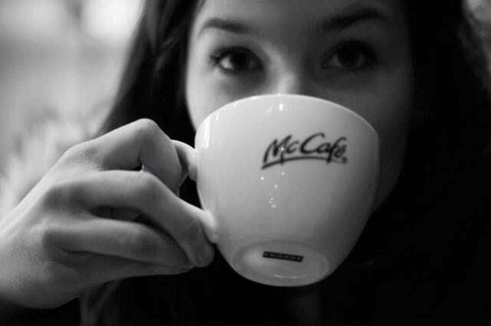 マクドナルドのコーヒーを飲む女性