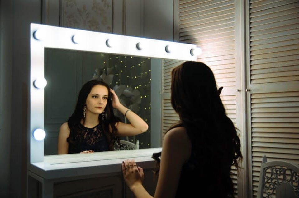 シャンプーの頻度が多く頭皮に違和感を感じて鏡を見る女性