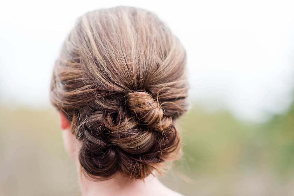 ハイライトが入ったロングの髪を結婚式に向けて三つ編みと編み込みを駆使してヘアアレンジをした女性
