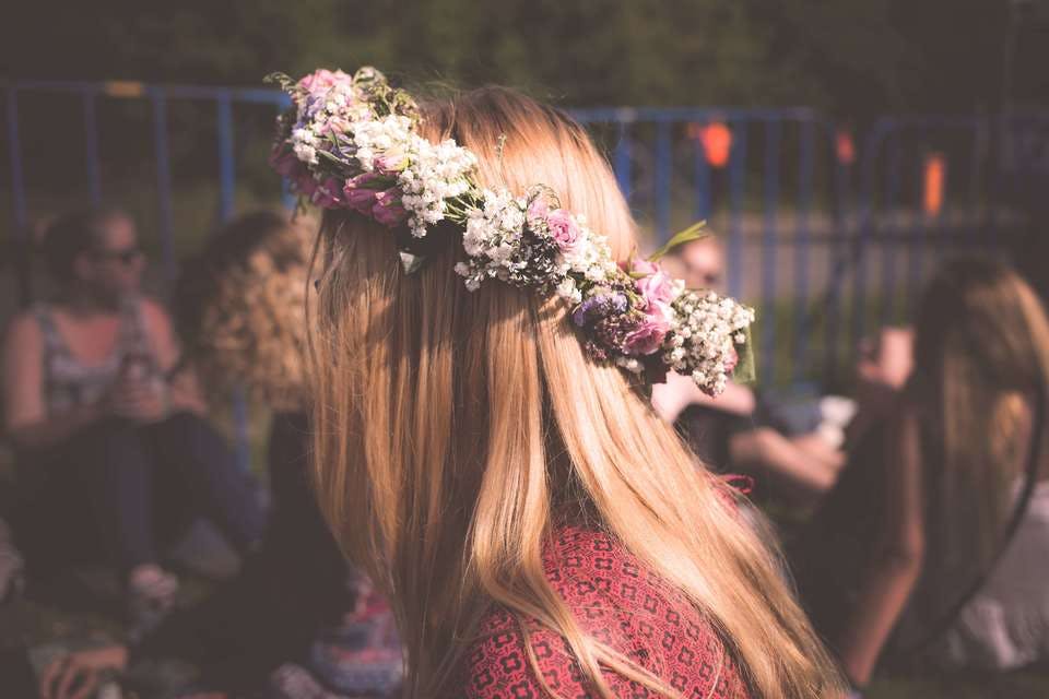 金髪のロングヘアーの人が結婚式のヘアアレンジに造花を使っている
