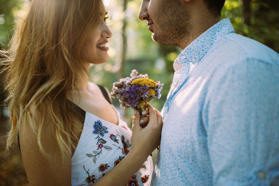 プロポーズには小さすぎる花束を持つカップル