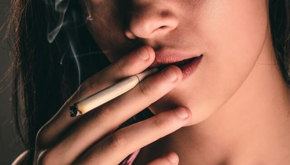 喫煙で唇のくすみが進む女性