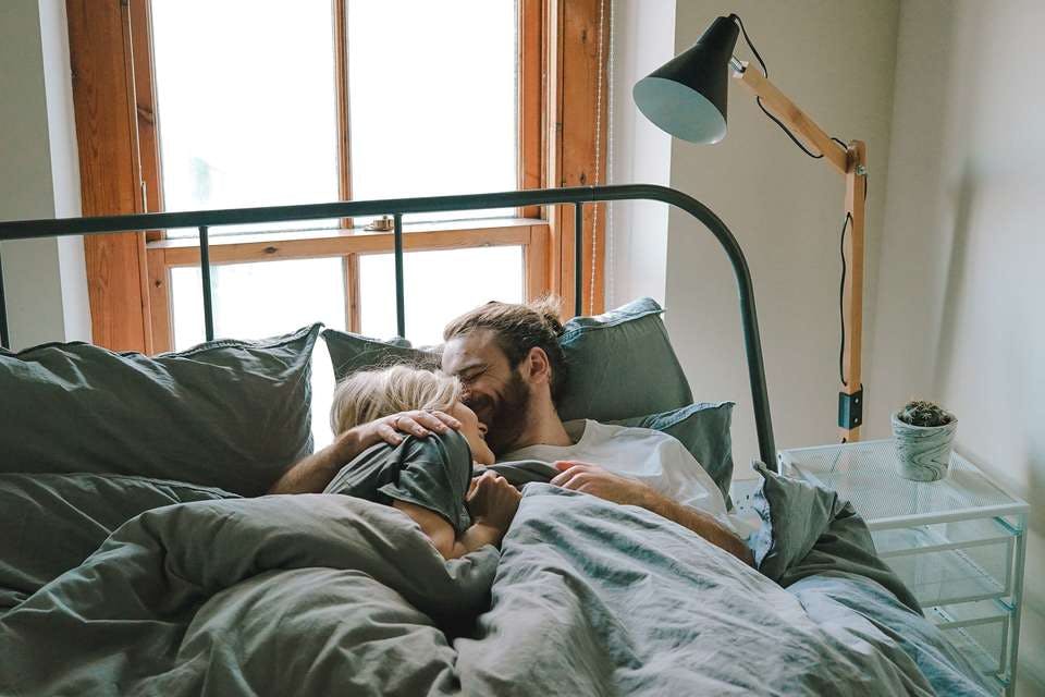 ベッドにいる結婚前の同棲カップル