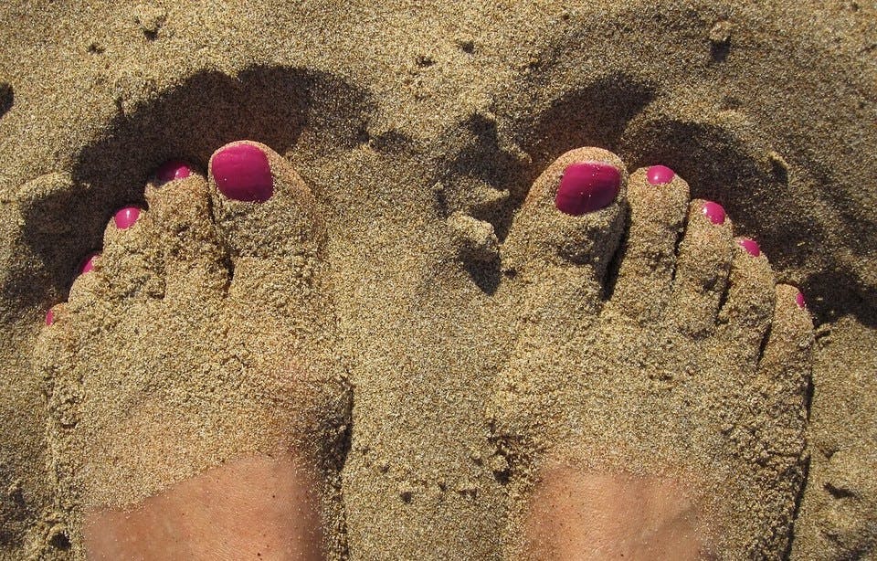 砂浜とピンク系フットネイル