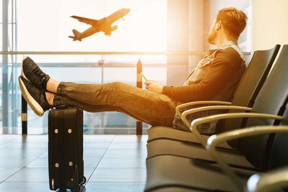 海外の遠距離恋愛で不安な男性が空港で待つ